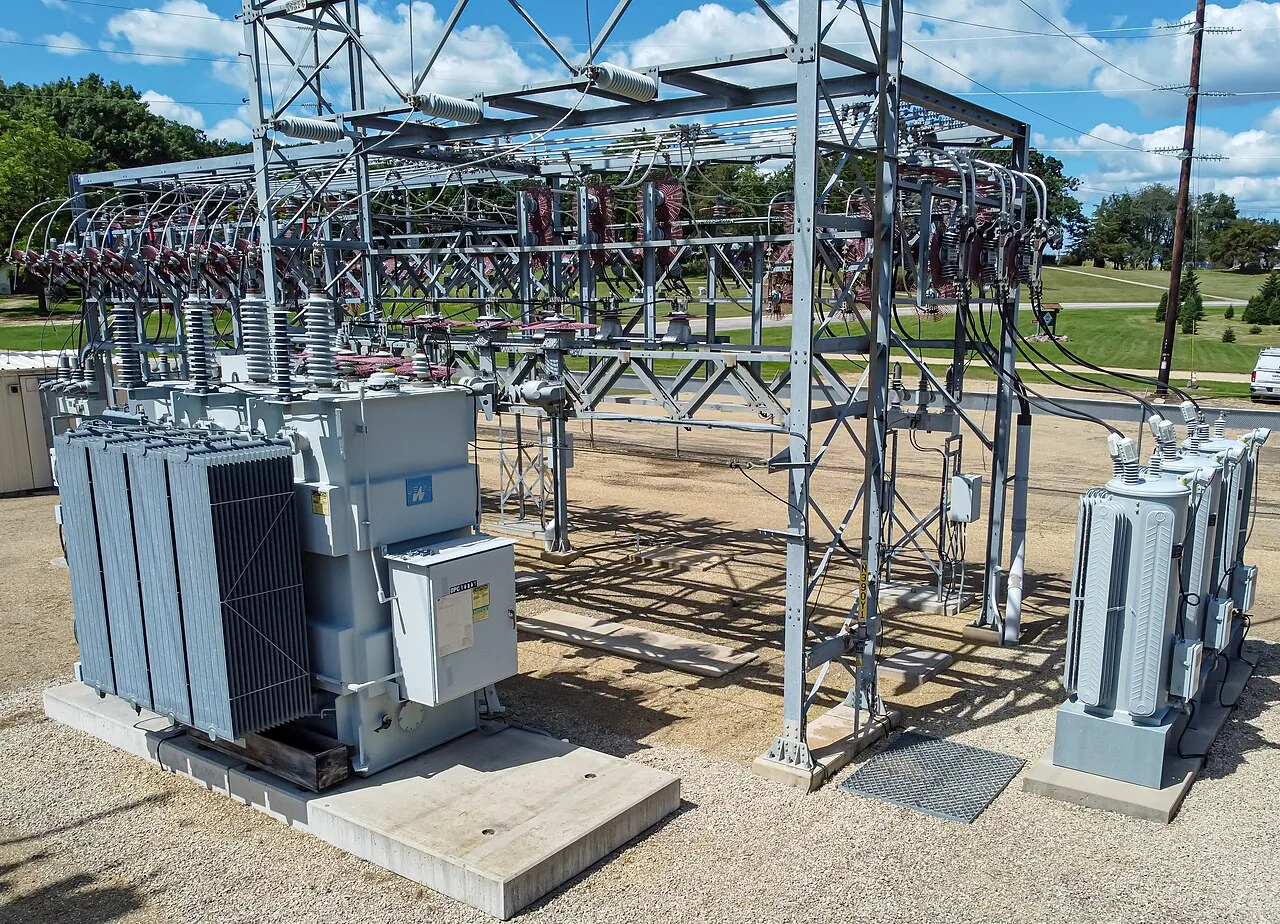 Transformers, insulators, and wiring at an outdoor electrical substation.