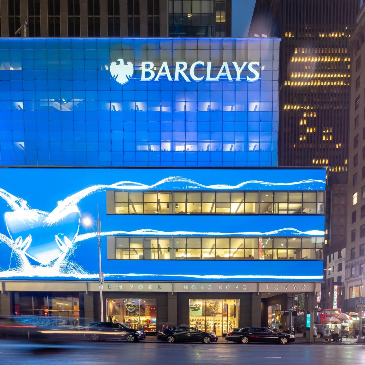 The brightly lit Barclays facade in Midtown Manhattan at night.