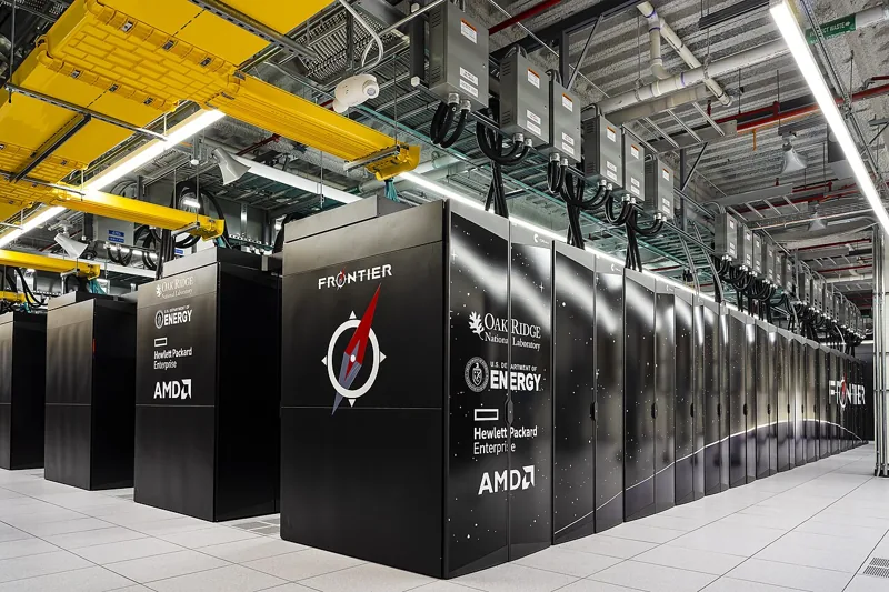 Frontier supercomputer cabinets and overhead cooling infrastructure at Oak Ridge National Laboratory.